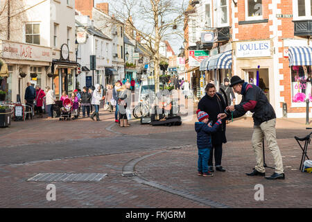 Un vendeur de ballons de la rue prend de l'argent d'un enfant pour un ballon dans le centre-ville de Cornwall. Banque D'Images