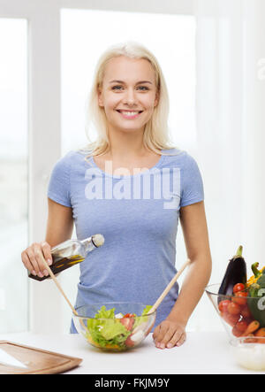 Smiling woman la cuisson de légumes grillés à la maison Banque D'Images