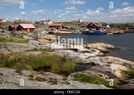 La côte rocheuse et rouge traditionnel falu maisons de pêcheurs, l'île de Käringön, Bohuslän, côte sud-ouest de la Suède, Suède Banque D'Images