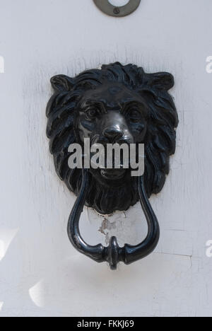 Une tête de lion noir heurtoir sur une porte, d'une maison d'habitation. Banque D'Images