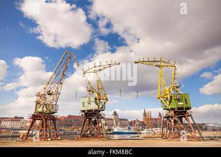 Trois grues vieux debout près de la rivière Odra à Szczecin, sites touristiques de la ville à distance, la Pologne. Banque D'Images