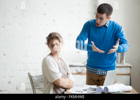 Portrait de deux collaborateurs faisant valoir au travail. Le personnel dans le milieu de l'argument à un bureau moderne. Les jeunes furieux man yelling Banque D'Images