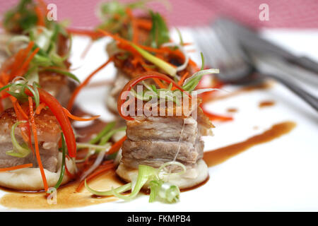 Flanc de porc rôti délicieux cubes dans la purée de pommes de terre avec sauce au caramel Banque D'Images