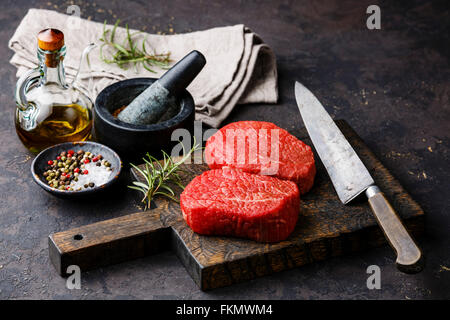 Frais crus de viande marbrée Steaks avec les assaisonnements sur fond sombre Banque D'Images