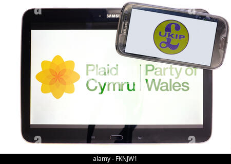 Le Plaid Cymru, UKIP et logos affichés sur les écrans d'une tablette et un smartphone sur un fond blanc. Banque D'Images