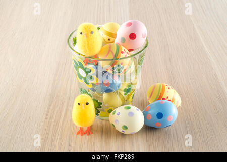 Pâques, petit poussin et les oeufs colorés dans un verre Banque D'Images