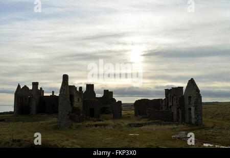 Le soleil se couche sur les ruines de Slains Castle, à côté de la baie de Cruden, Aberdeenshire, Ecosse. Banque D'Images