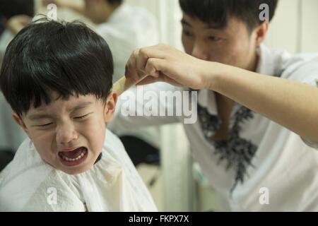 Huludao, province de Liaoning en Chine. 10 Mar, 2016. Un enfant pleure comme une coiffure lui donne une coupe de cheveux à un coiffeur à l'Longtaitou Festival à Huludao, nord-est de la Chine, la province de Liaoning, 10 mars 2016. Le Longtaitou Eryueer ou Festival, Festival, ce qui signifie 'dragon soulève tête" en chinois, est un festival traditionnel chinois tenue le deuxième jour du deuxième mois dans le calendrier lunaire chinois. Les Chinois détiennent la conviction que le fait d'obtenir une coupe quand le 'dragon soulève sa tête' signifie qu'ils auront un départ énergique à la nouvelle année. © Tian Jia/Xinhua/Alamy Live News Banque D'Images