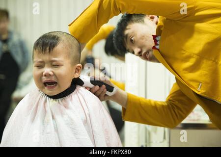 Huludao, province de Liaoning en Chine. 10 Mar, 2016. Un enfant pleure comme une coiffure lui donne une coupe de cheveux à un coiffeur à l'Longtaitou Festival à Huludao, nord-est de la Chine, la province de Liaoning, 10 mars 2016. Le Longtaitou Eryueer ou Festival, Festival, ce qui signifie 'dragon soulève tête" en chinois, est un festival traditionnel chinois tenue le deuxième jour du deuxième mois dans le calendrier lunaire chinois. Les Chinois détiennent la conviction que le fait d'obtenir une coupe quand le 'dragon soulève sa tête' signifie qu'ils auront un départ énergique à la nouvelle année. © Tian Jia/Xinhua/Alamy Live News Banque D'Images
