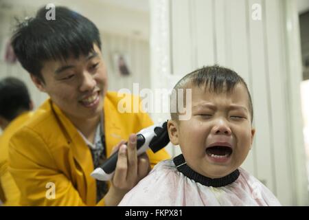Huludao, province de Liaoning en Chine. 10 Mar, 2016. Un enfant pleure comme une coiffure lui donne une coupe de cheveux à un coiffeur à l'Longtaitou Festival à Huludao, nord-est de la Chine, la province de Liaoning, 10 mars 2016. Le Longtaitou Eryueer ou Festival, Festival, ce qui signifie 'dragon soulève tête" en chinois, est un festival traditionnel chinois tenue le deuxième jour du deuxième mois dans le calendrier lunaire chinois. Les Chinois détiennent la conviction que le fait d'obtenir une coupe quand le 'dragon soulève sa tête' signifie qu'ils auront un départ énergique à la nouvelle année. © Tian Jia/Xinhua/Alamy Live News Banque D'Images
