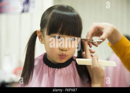 Huludao, province de Liaoning en Chine. 10 Mar, 2016. Un enfant fait face à une coiffure lui donne une coupe de cheveux à un coiffeur à l'Longtaitou Festival à Huludao, nord-est de la Chine, la province de Liaoning, 10 mars 2016. Le Longtaitou Eryueer ou Festival, Festival, ce qui signifie 'dragon soulève tête" en chinois, est un festival traditionnel chinois tenue le deuxième jour du deuxième mois dans le calendrier lunaire chinois. Les Chinois détiennent la conviction que le fait d'obtenir une coupe quand le 'dragon soulève sa tête' signifie qu'ils auront un départ énergique à la nouvelle année. © Tian Jia/Xinhua/Alamy Live News Banque D'Images