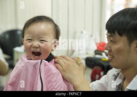 Huludao, province de Liaoning en Chine. 10 Mar, 2016. Un enfant se prépare à se couper les cheveux à un coiffeur à l'Longtaitou Festival à Huludao, nord-est de la Chine, la province de Liaoning, 10 mars 2016. Le Longtaitou Eryueer ou Festival, Festival, ce qui signifie 'dragon soulève tête" en chinois, est un festival traditionnel chinois tenue le deuxième jour du deuxième mois dans le calendrier lunaire chinois. Les Chinois détiennent la conviction que le fait d'obtenir une coupe quand le 'dragon soulève sa tête' signifie qu'ils auront un départ énergique à la nouvelle année. © Tian Jia/Xinhua/Alamy Live News Banque D'Images