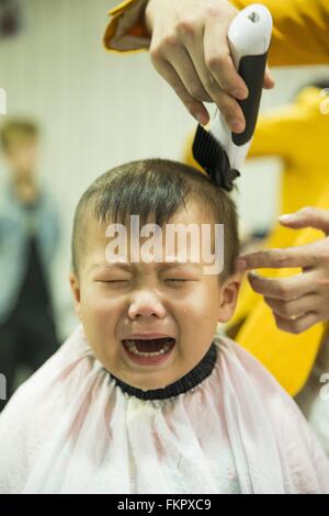 Huludao, province de Liaoning en Chine. 10 Mar, 2016. Un enfant pleure comme une coiffure lui donne une coupe de cheveux à un coiffeur à l'Longtaitou Festival à Huludao, nord-est de la Chine, la province de Liaoning, 10 mars 2016. Le Longtaitou Eryueer ou Festival, Festival, ce qui signifie 'dragon soulève tête" en chinois, est un festival traditionnel chinois tenue le deuxième jour du deuxième mois dans le calendrier lunaire chinois. Les Chinois détiennent la conviction que le fait d'obtenir une coupe quand le 'dragon soulève sa tête' signifie qu'ils auront un départ énergique à la nouvelle année. © Tian Jia/Xinhua/Alamy Live News Banque D'Images