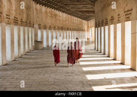 La marche des moines dans le couloir d'entrée de Shwezigon Paya, Bagan, Myanmar Banque D'Images