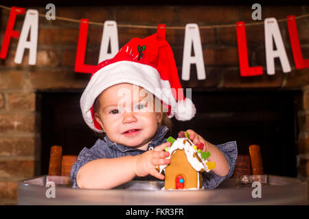 Caucasian boy holding gingerbread house Banque D'Images