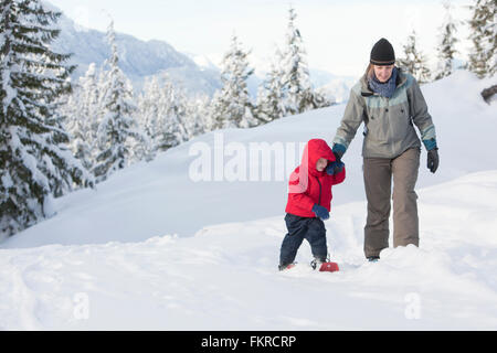 Caucasian mother and son raquette on hillside Banque D'Images