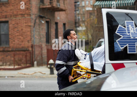 Mixed Race chargement en ambulance ambulancier patient Banque D'Images