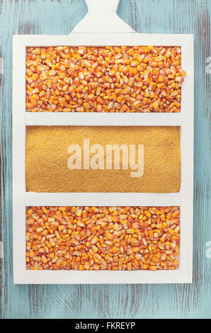 Grains de maïs et de la semoule. Coup de frais généraux avec la semoule de maïs en grains sur planche de bois Banque D'Images