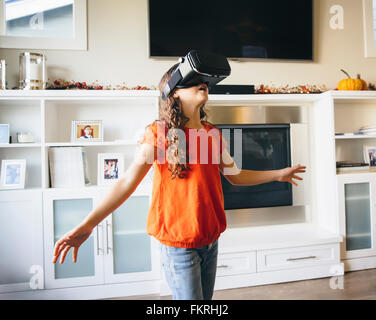 Mixed Race girl en utilisant des lunettes de réalité virtuelle Banque D'Images