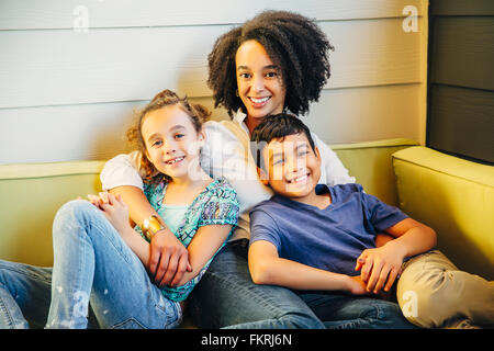 Mère et enfants relaxing on sofa Banque D'Images