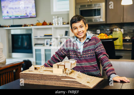 Mixed Race boy smiling with model house Banque D'Images