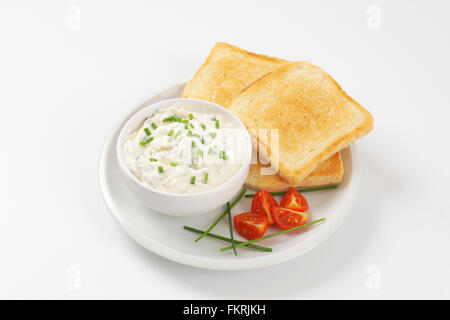 Toasts frais et bol de ciboulette propagation on white plate Banque D'Images