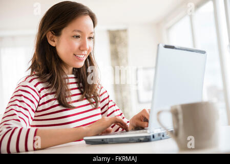 Mixed Race woman using laptop Banque D'Images