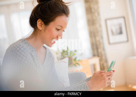 Mixed Race woman using cell phone Banque D'Images