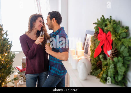 Couple drinking champagne at Christmas Banque D'Images