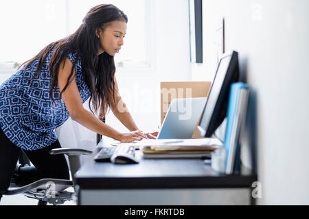Mixed Race businesswoman working in office Banque D'Images