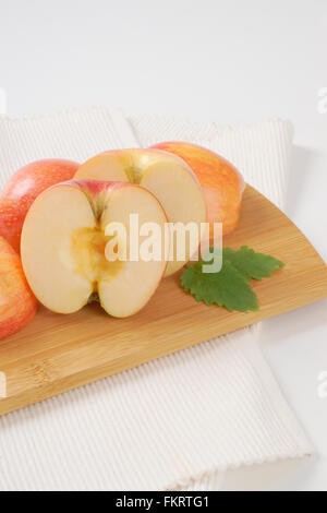 Des pommes mûres sur planche à découper en bois et blanc set de table Banque D'Images