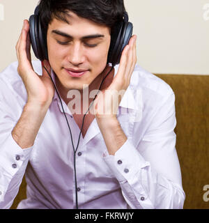 Mixed Race man listening to headphones Banque D'Images