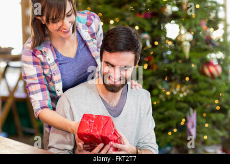 Hispanic couple exchanging Christmas gifts Banque D'Images