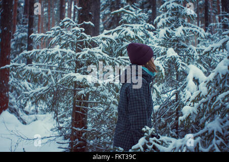 Caucasian woman standing in snowy forest Banque D'Images