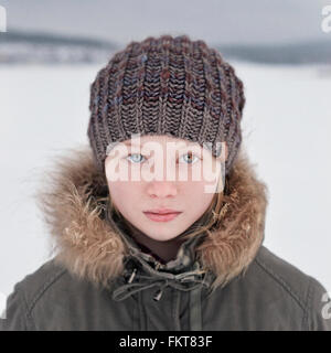 Caucasian teenage girl wearing beanie hat in snow Banque D'Images