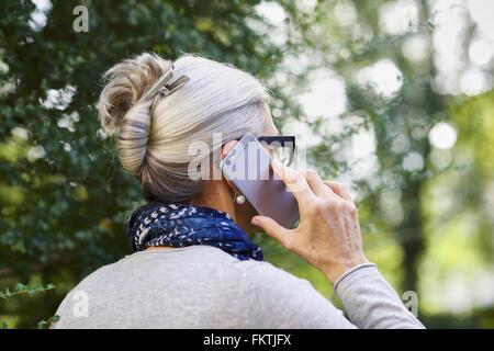 Woman using smartphone outdoors Banque D'Images