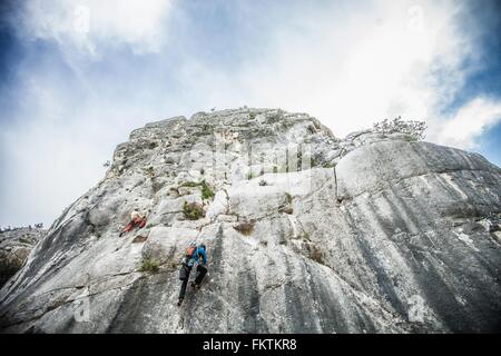 Vue arrière de l'angle faible rock climber climbing up montagne, Ogliastra, Sardaigne, Italie Banque D'Images