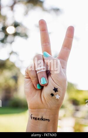 Woman making peace sign with hand Banque D'Images