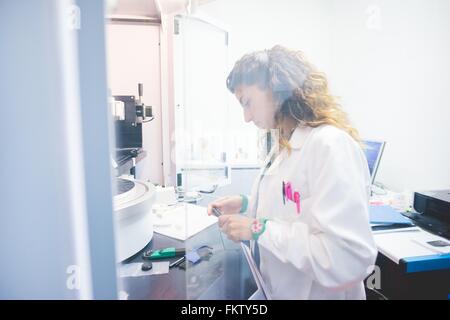 Female scientist la préparation de l'échantillon à film mince à la mesure à l'aide d'un diffractomètre de rayons x Banque D'Images