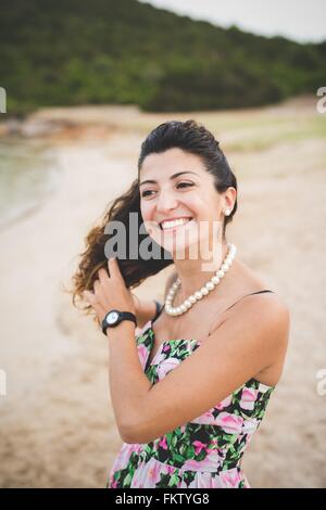 Femme à la plage, les mains dans les cheveux Banque D'Images