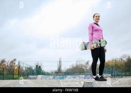 Portrait de jeune femme en skateboard skateur exerçant son parc de planche à roulettes