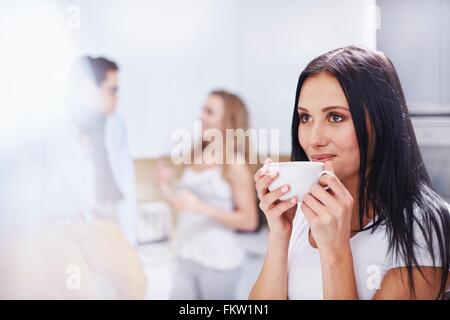 Jeune femme à boire c frais en cuisine Banque D'Images