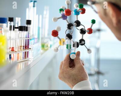 Scientist holding molecular model in laboratory Banque D'Images