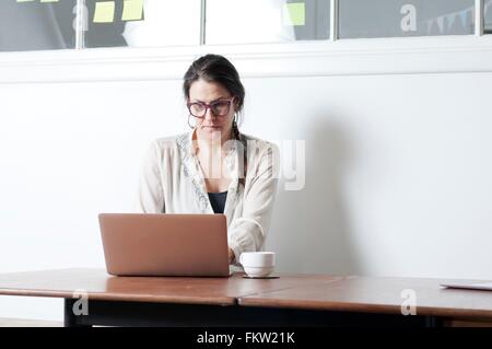 Woman using laptop at desk Banque D'Images