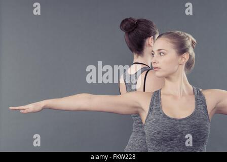 Les jeunes femmes pratiquant le yoga, fond gris Banque D'Images