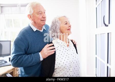 Senior couple in office looking out de fenêtre Banque D'Images