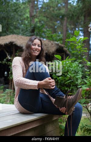 Portrait of young woman bottes sur porche chalet Banque D'Images