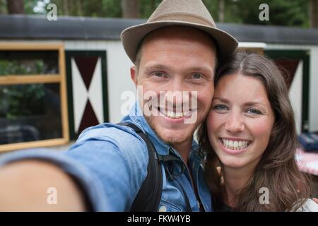 Couple heureux en tenant le porche cabine selfies Banque D'Images