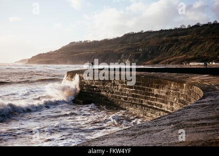 Deux personnes à la recherche en mer agitée à partir de 'Le mur' Harbour Cobb, Lyme Regis, dans le Dorset, Angleterre Banque D'Images