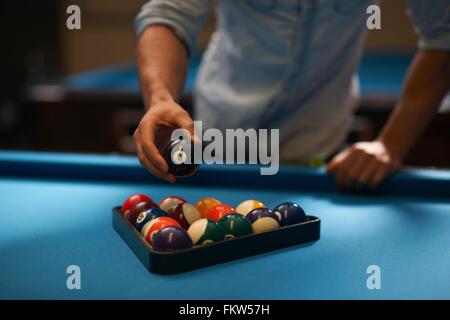 L'homme l'organisation des balles dans triangle sur table de billard Banque D'Images